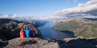 Norsk fjeld med vandrere der nyder udsigten over fjord og fjelde