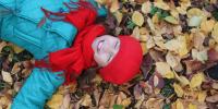 Pige ligger i efterårsblade