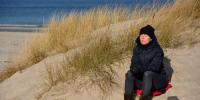 foto af Kvinde der sidder og nyder vintersolen på en strand