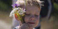 Dreng med blomster aer sin kind 