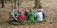 gruppe mennesker sidder i skoven 