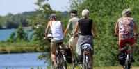På bileldet ses 4 pensionister på cykeltur i det danske sommerlandskab. De bærer alle somemrtøj og har ryggen mod kameraet