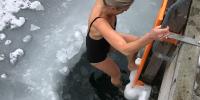 Kvinder vinterbader fra badebro. Der er is på vandet