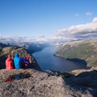 Norsk fjeld med vandrere der nyder udsigten over fjord og fjelde