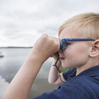 Dreng kigger på fugle i Naturpark Randers Fjord